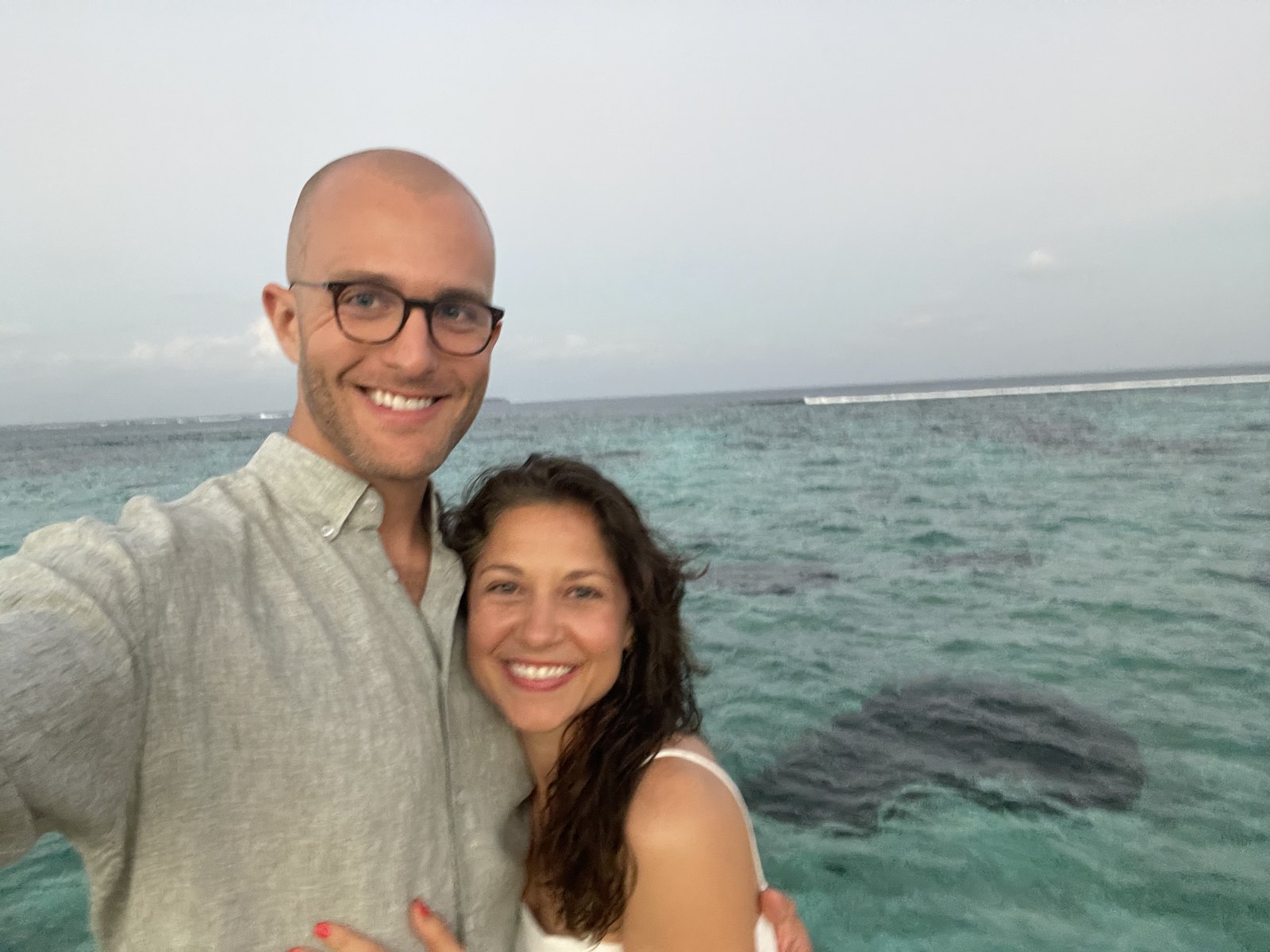 Thomas and Teri smiling over the turquoise lagoon at Laamu